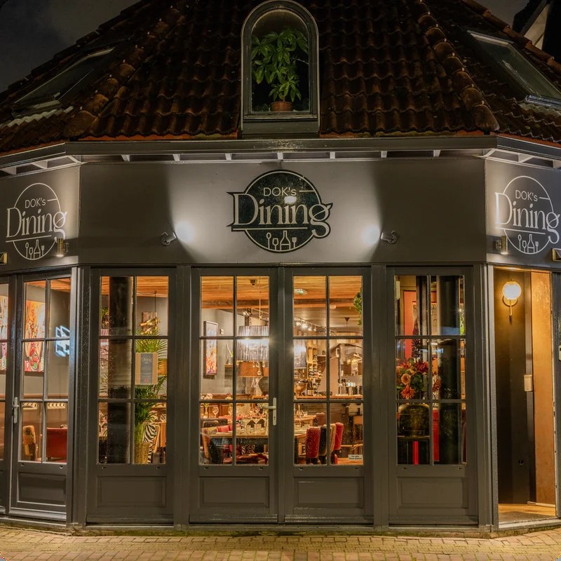De gevel van DOK's Dining aan de Dorpsstraat in Castricum, bij avond